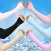 A group of people wearing various colored cooling UV protection arm sleeves are shown splashing in blue water.