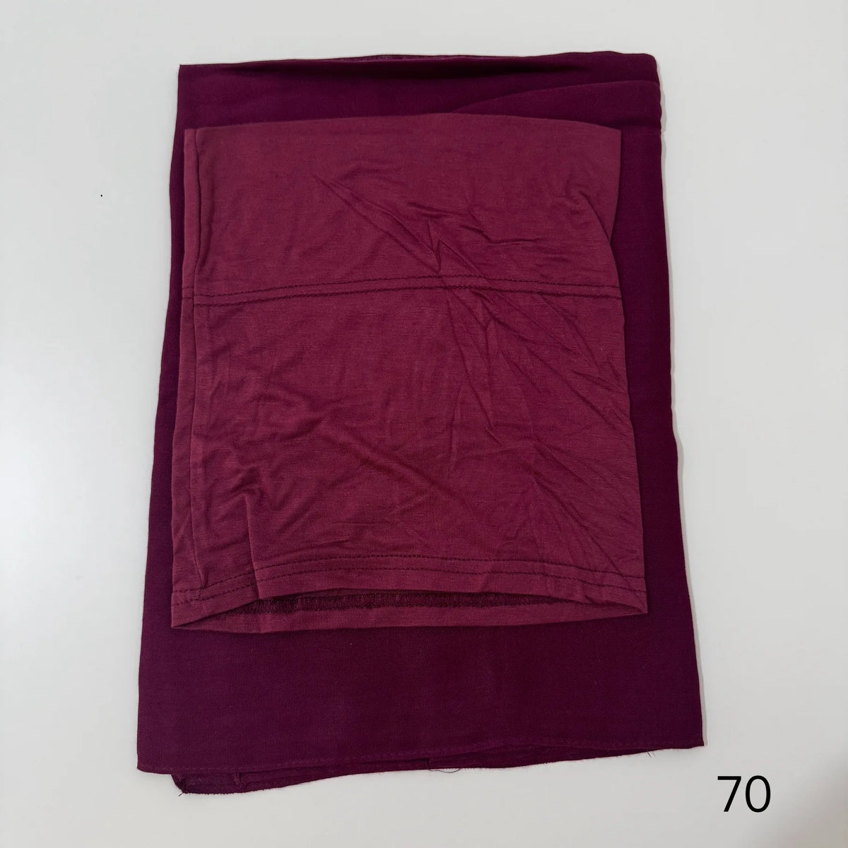 A deep magenta soft modal rayon hijab set folded flat on a white surface.