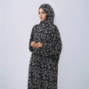 A woman wearing an elegant black and white patterned Muslim hijab dress for daily wear.