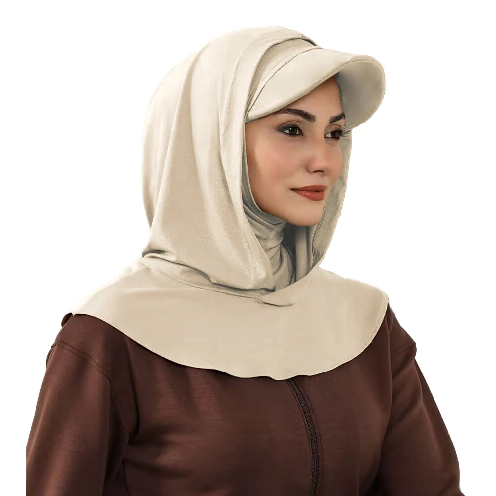 Une femme portant un bonnet hijab beige couvrant et un haut marron.
