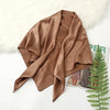 A draped solid brown silk satin hijab scarf resting on a white surface next to fluffy white fur.