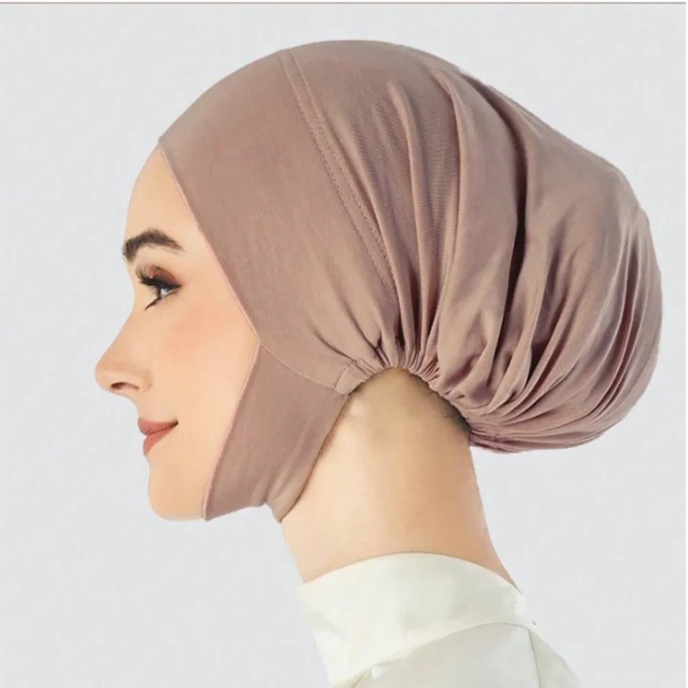 Une modèle portant un hijab de sous-voile beige uni, vue de profil.