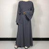 Une longue abaya gris anthracite simple avec une ceinture nouée et un foulard beige clair.