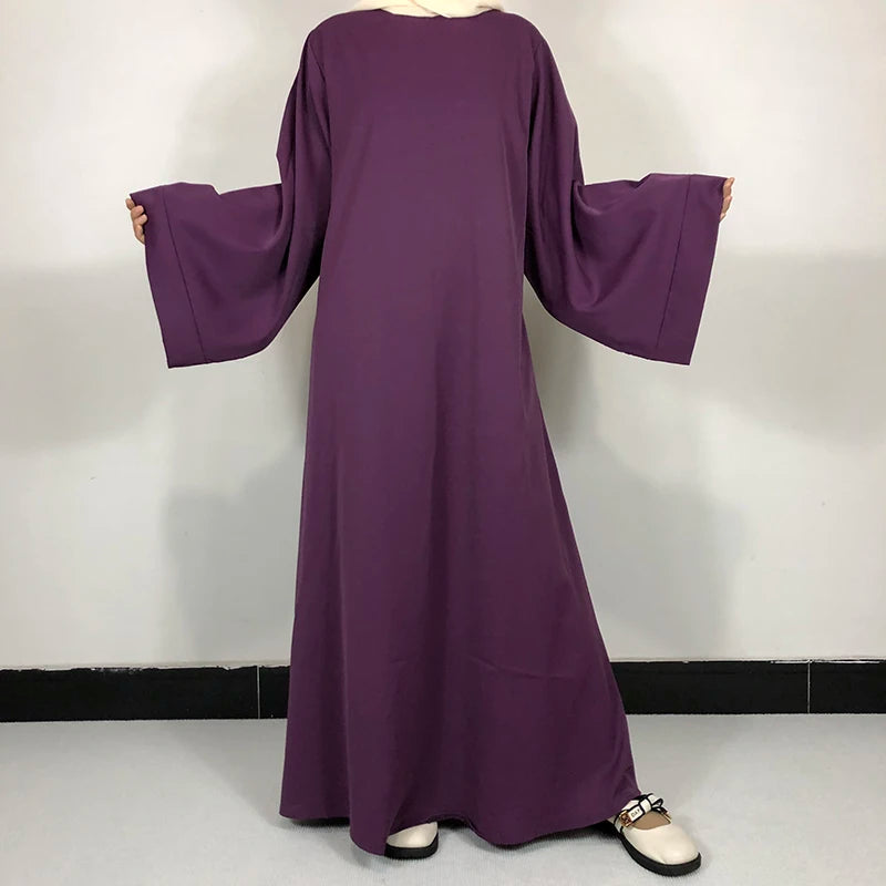 Une robe abaya violette simple exposée sur un mannequin.