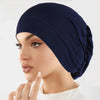 Nahaufnahme einer Frau, die eine dunkelblaue vielseitige Stretch-Turbanmütze trägt.