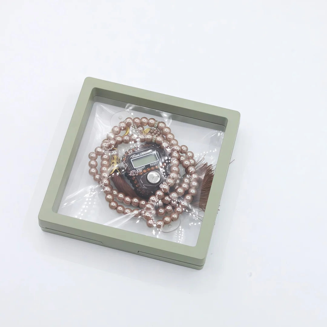 A digital counter bracelet with prayer beads is displayed in a light green rectangular case.