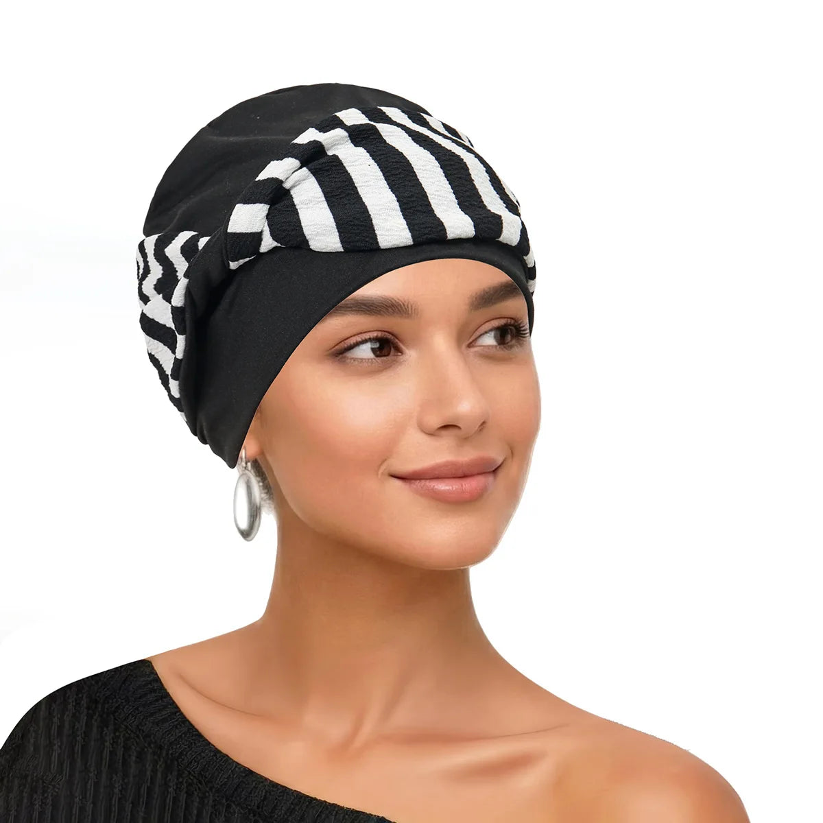 Eine Frau modelliert einen schwarz-weißen gestreiften Turban auf ihrem Kopf.