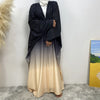 Una mujer vistiendo una elegante bata de cardigan islámica negra y beige con un hiyab blanco.