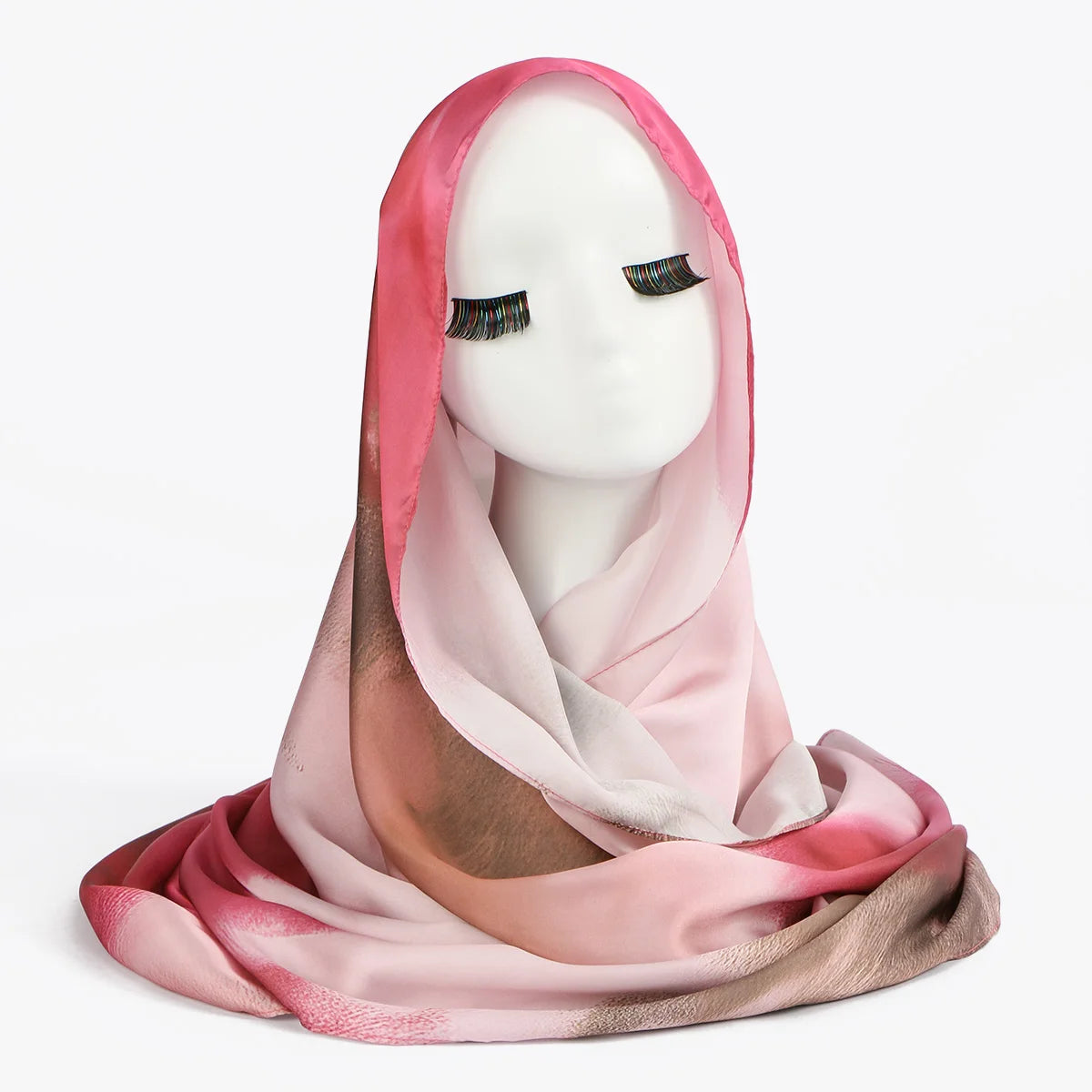 Rosa und beige schimmernder Seidenschal, drapiert über einen weißen Mannequin-Kopf.