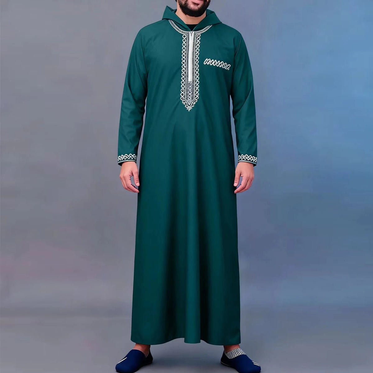 A man wearing a dark teal Moroccan embroidered thobe jellaba with silver trim.