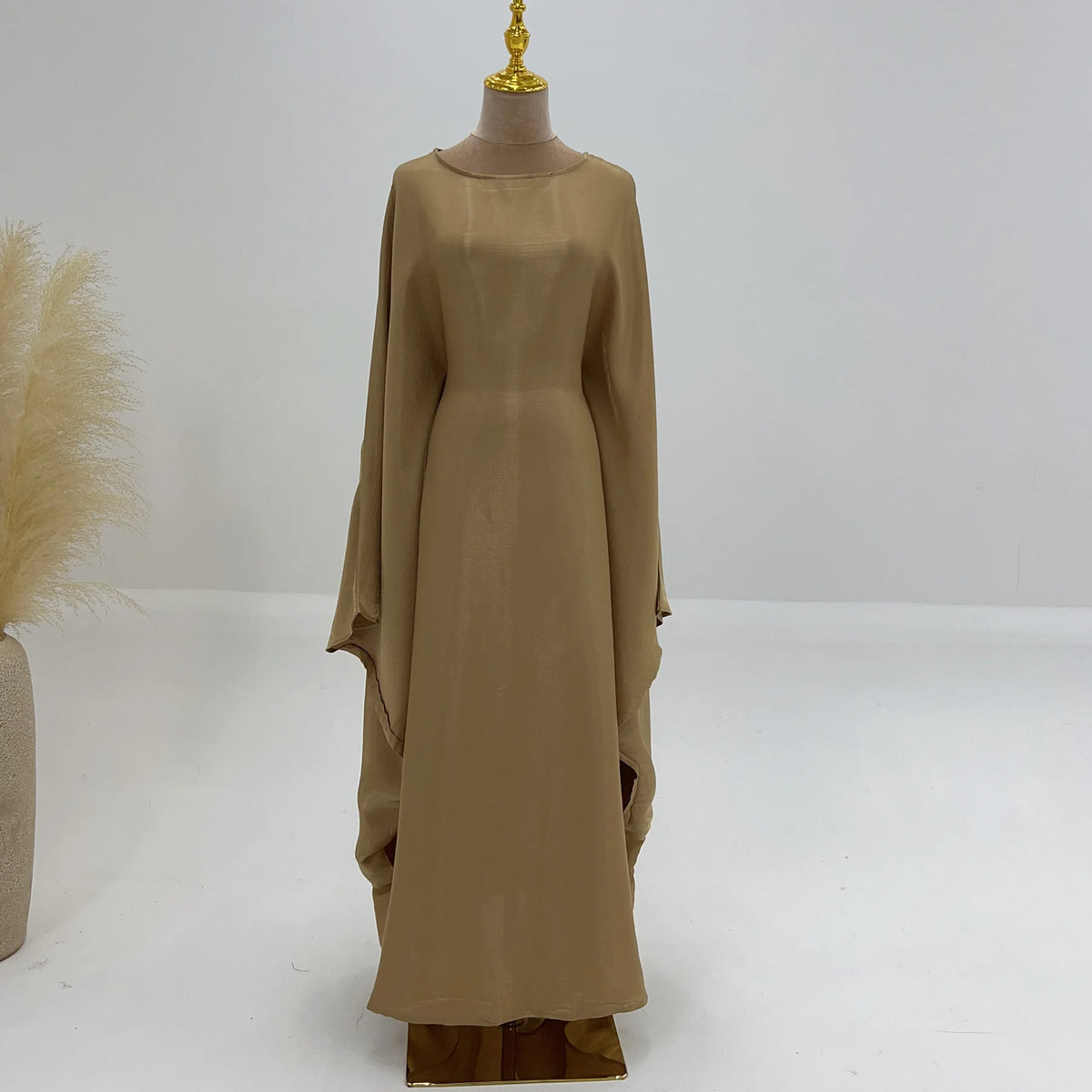 Beige elegante Langarm-Abaya auf einem Mannequin.