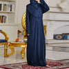 Una elegante caftán de abaya islámica azul oscuro usada por una modelo en un interior lujoso.