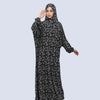 A woman wearing an elegant black and white patterned Muslim hijab dress for prayer and daily wear.