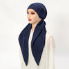 Une femme portant un bonnet hijab en lin bleu marine uni avec un haut blanc.