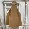 Beige elegante Maxi-Abaya über einem Aufsteller vor aufwendigem weiß-goldenem architektonischem Hintergrund.