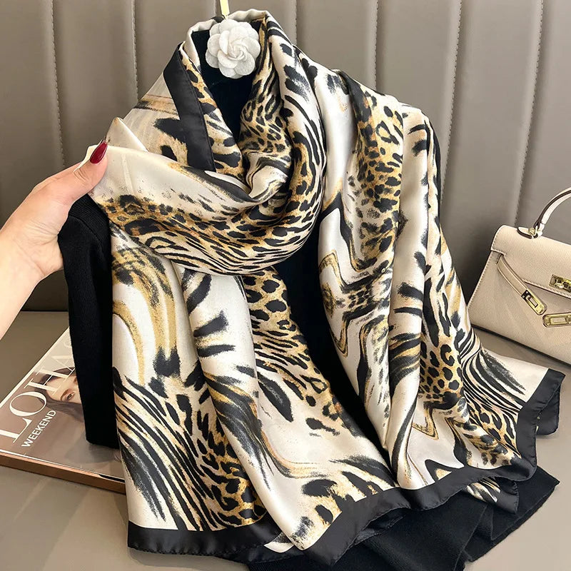 Luxuriöses beige und schwarzes Leopardenmuster-Seidelschal über einem dunklen Kleidungsstück.
