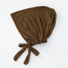 Ein einfarbiger brauner, mehrfarbiger Turban-Inner-Hijab-Bonnet, gefaltet und auf weißem Hintergrund präsentiert.