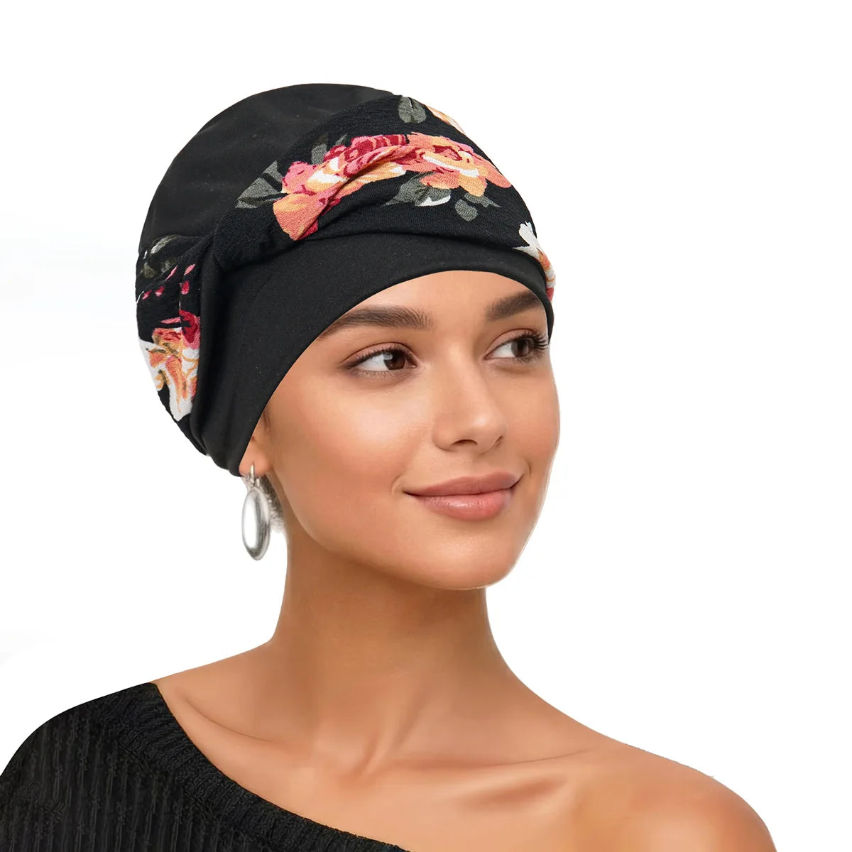 Eine Frau modelliert einen schwarzen Turban mit Blumenmuster auf Kopf und Schulter.