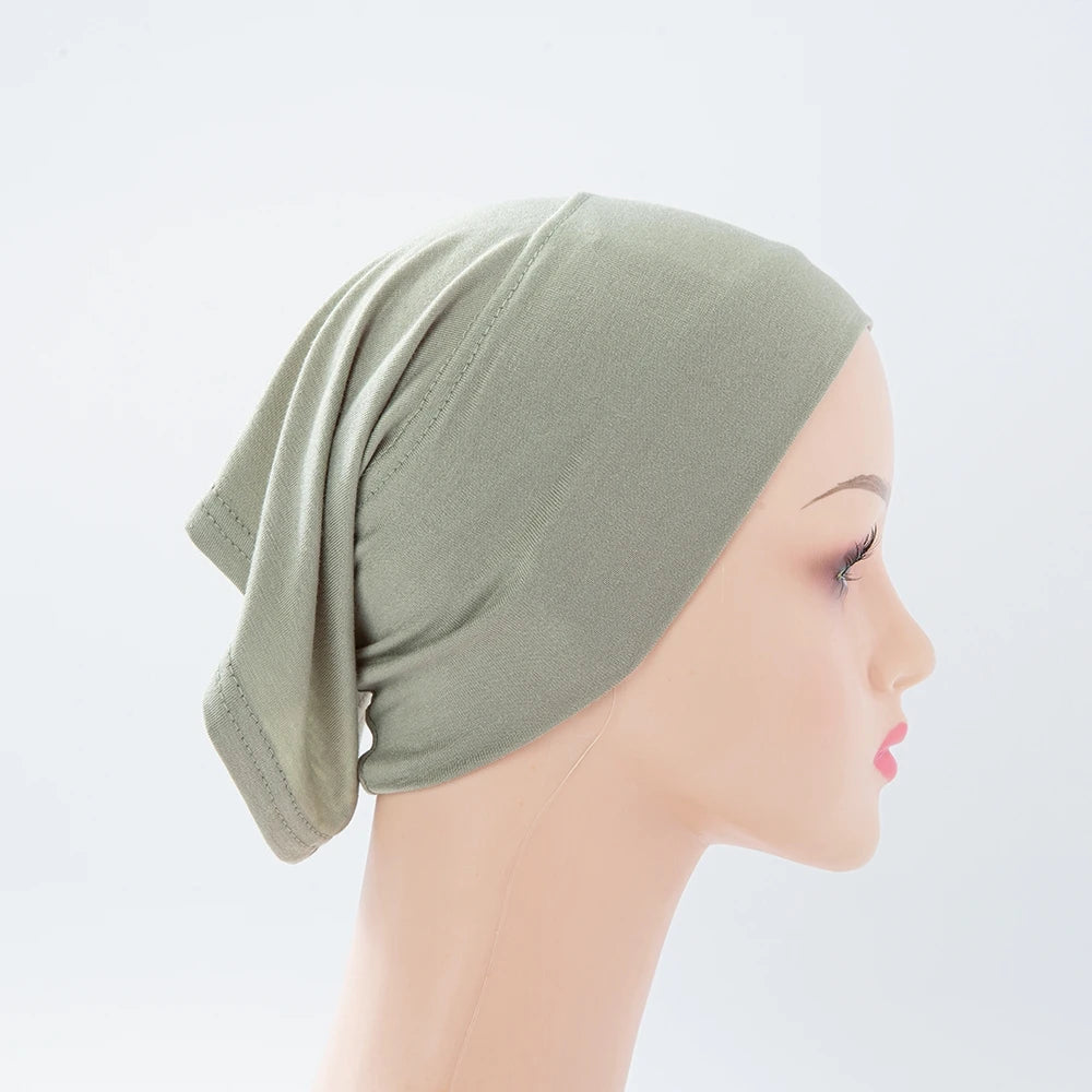 Helle olivgrüne Bambus-Jersey-Turbanmütze auf einem Mannequin-Kopf.