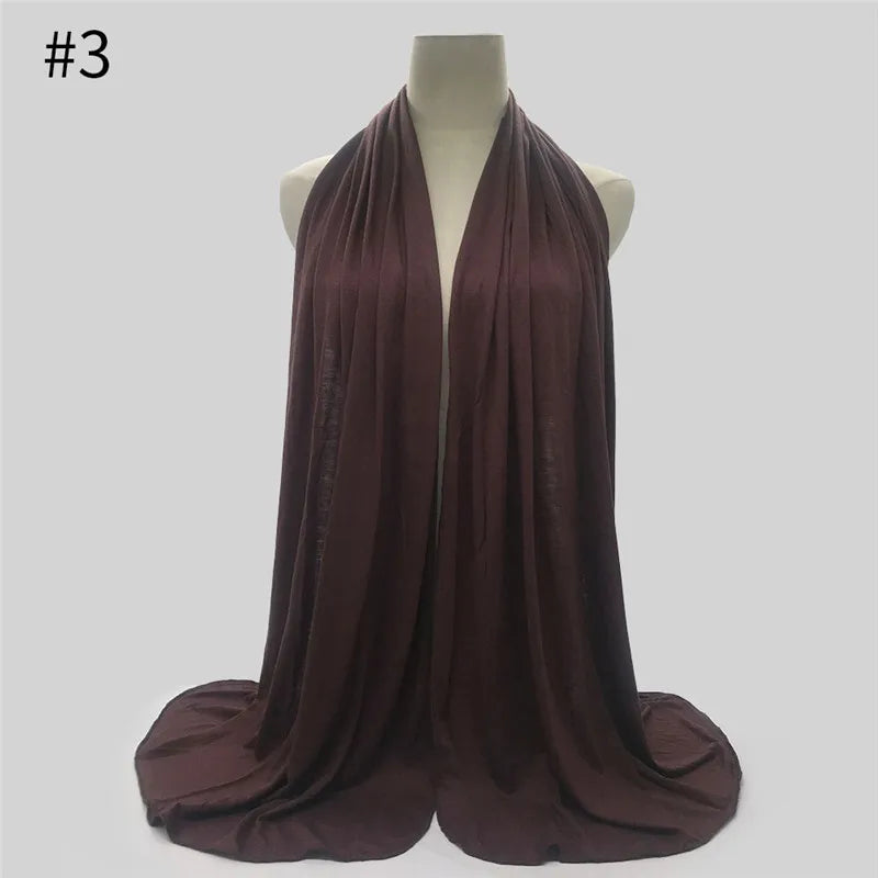 Dunkelviolettfarbiger Baumwoll-Jersey-Hijab-Schal, drapiert auf einem Mannequin.