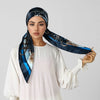 Eine Frau modelliert einen dunkelblauen Seiden-Instant-Hijab-Schal mit goldenen Stickereien vor hellem Hintergrund.