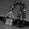 Porte-clés islamiques arabes en perles noires de Allah, exposés sur une surface sombre.
