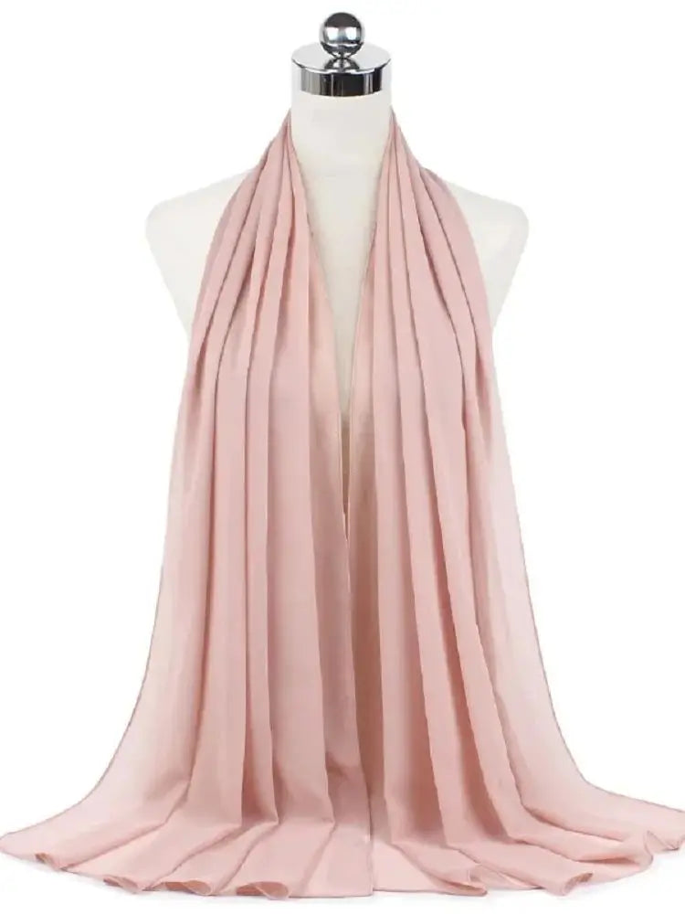 Ein weicher rosa Chiffon-Hijabschal elegant auf einem Mannequin drapiert.