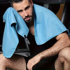 Un homme portant une serviette de voyage en microfibre à séchage rapide bleu clair drapée sur son épaule.