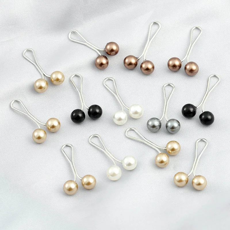 Sammlung von silbernen Drop-Pins mit Perlen und schwarzen Perlen zum Halten von Hijab und Schals.