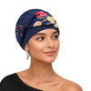 Eine Frau modelliert einen dunkelblauen gebundenen Turban mit Blumenmuster.