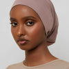 Model wearing a beige bamboo jersey tube hijab cap with natural skin tone.