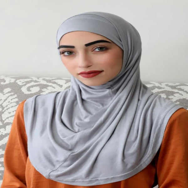A woman wearing a gray modal cotton hijab scarf set with an orange top.