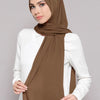 A woman wearing a brown chiffon matching inner scarf set with a white top.
