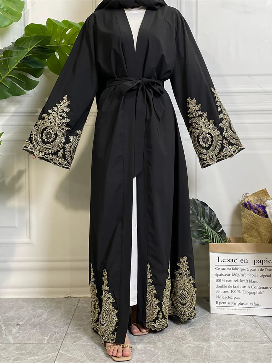 Abaya kaftan de lujo negra con bordado dorado y hijab negro usada por una modelo.