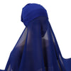 Un conjunto de hiyab y chal de gasa azul profundo drapeado sobre una cabeza.