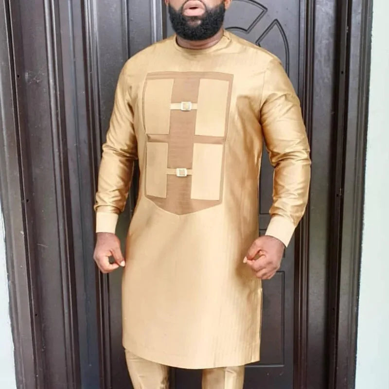 Un homme portant un costume de mariage musulman traditionnel africain beige avec des détails brodés.