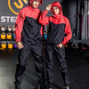 Deux modèles portant des combinaisons de sauna fitness noir et rouge dans une salle de sport.