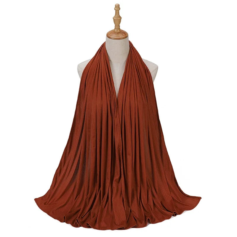Pañuelo de jersey de algodón con hilo color óxido drapeado alrededor del cuello de un maniquí.