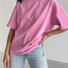 Una modelo vistiendo una camiseta básica de algodón rosa oversize y jeans de lavado claro.