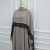 Vestido abaya largo y suelto color topo con detalles de encaje negro en el bajo y escote.