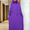 Abaya de algodón morado con doble sombrero y decoración floral exhibida en un pasillo.