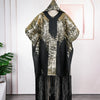 Traditionelles afrikanisches Dashiki Maxi-Kleid in schwarz und gold, präsentiert an einem Haken vor einer rosa Wand.