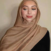 Eine Frau trägt einen beige-gradienten Rayon-Modal-Hijabschal und schwarze Kleidung.