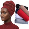 Model in deep red turban and matching top, with rolled fabric samples nearby.