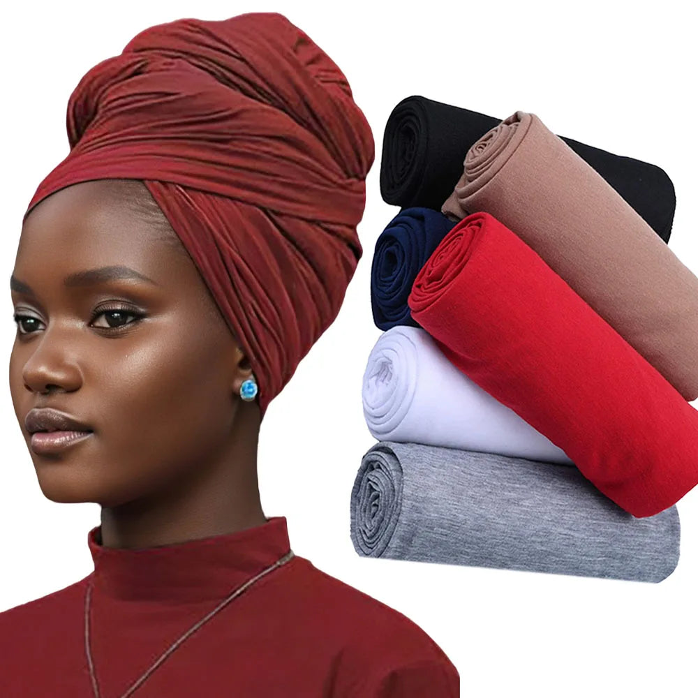 Model in deep red turban and matching top, with rolled fabric samples nearby.