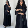 Eine Frau modelliert einen eleganten schwarzen Abaya-Cardigan-Kleid mit Polka-Dot-Muster und langen Ärmeln.