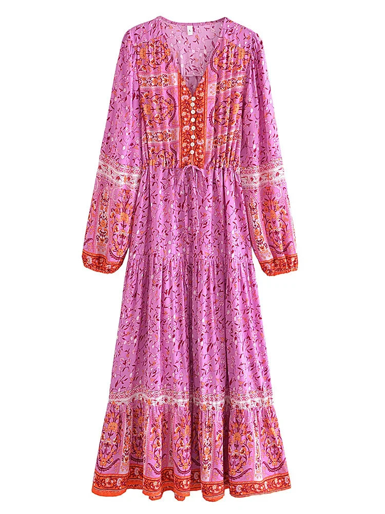 A long-sleeved pink floral maxi dress with intricate embroidery and ruffled hem.