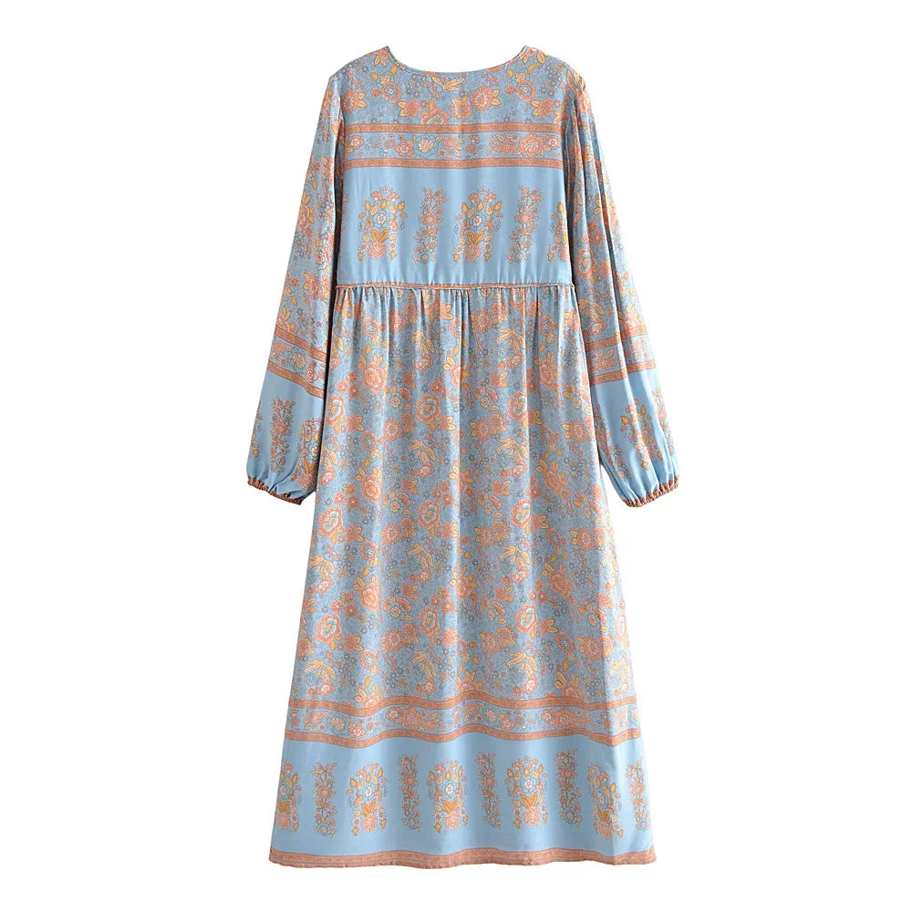 A light blue bohemian floral maxi dress featuring lantern sleeves and an all-over print of orange and blue flowers.