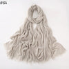 Foulard hijab en coton viscose beige clair drapé et flottant sur fond blanc.