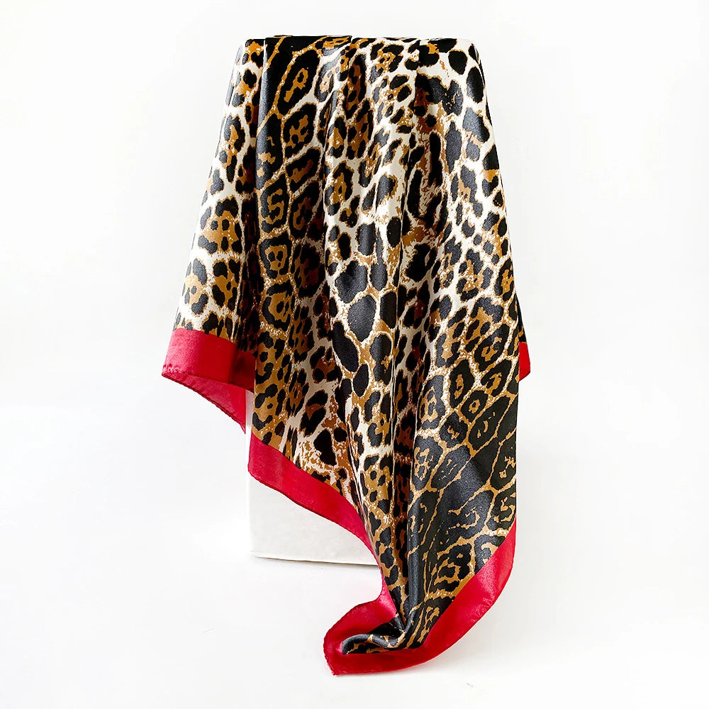 Pañuelo de seda cuadrado estampado de leopardo negro y dorado, drapeado verticalmente.